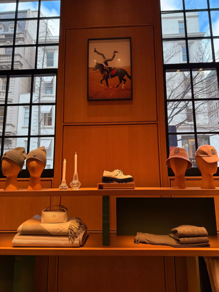 Elegancka przestrzeń handlowa z drewnianymi meblami retail, wyspami ekspozycyjnymi i podświetlanymi regałami.