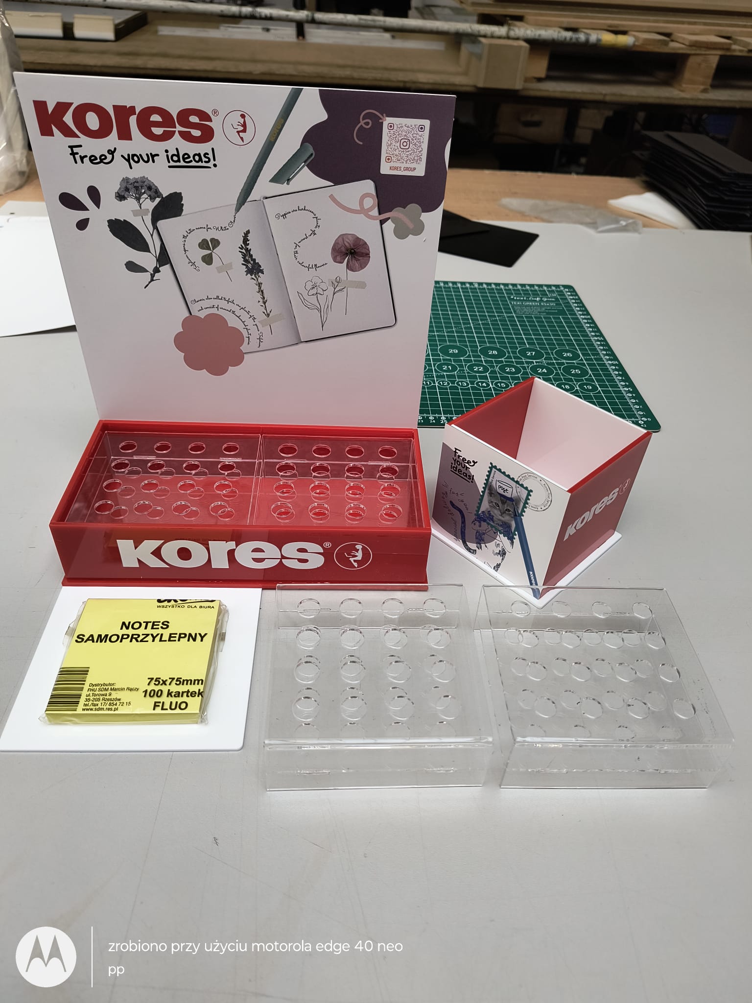 Disassembled acrylic display components prepared for assembly, including transparent PMMA inserts, printed panels and modular accessories.