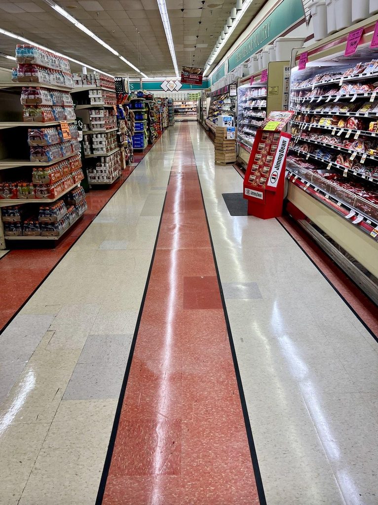 Wide retail shopping aisle designed for comfortable customer flow with unobstructed circulation between store shelves.